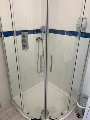 a shower with a glass door in a bathroom at Sirens Sunset Peaceful Retreat with stunning sea views, 5 minutes from Porth Beach in Newquay