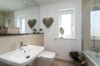 a bathroom with a sink and a toilet and hearts on the wall at Blue Water in St Ives
