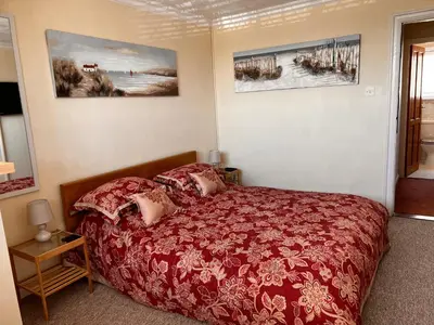 a bedroom with a red bed and two pictures on the wall at Shazzamm in Newquay