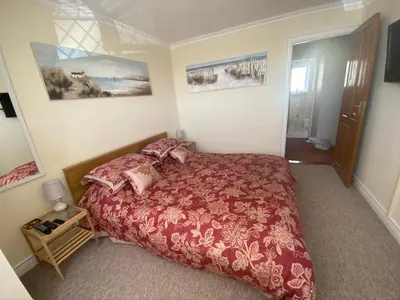 a bedroom with a large bed with a red bedspread at Shazzamm in Newquay