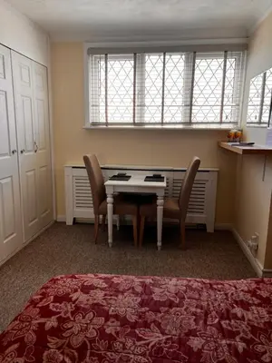 a bedroom with a desk and two chairs and a table at Shazzamm in Newquay