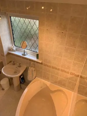 a bathroom with a toilet and a sink and a window at Shazzamm in Newquay