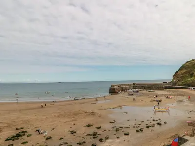 a group of people on a beach near the ocean at Dovecote in Saint Goran