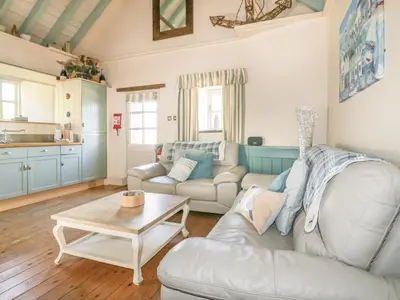 a living room with a couch and a table at Dovecote in Saint Goran