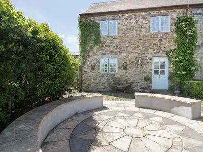 a brick house with a stone pathway in front of it at Owls Roost in Saint Goran