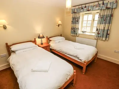 two twin beds in a room with a window at Foxes Den in Saint Goran