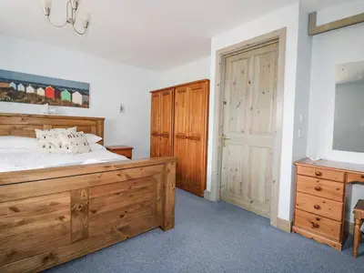 a bedroom with a large wooden bed and a dresser at Squirrels Dray in Saint Goran