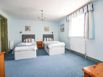 a bedroom with two beds and a window at Squirrels Dray in Saint Goran