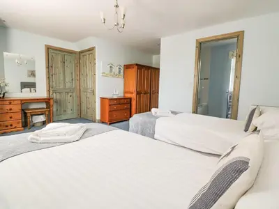 a bedroom with two beds and a desk and a mirror at Squirrels Dray in Saint Goran
