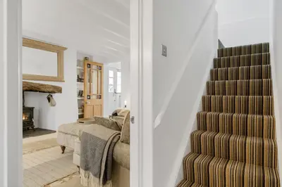 a stairway leading to a living room with a couch at Jade Cottage in St. Agnes