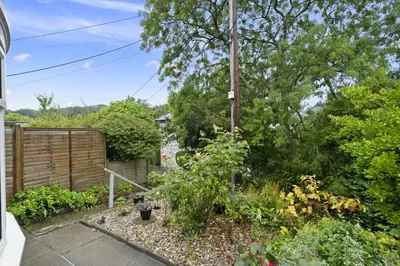 a garden with plants and a wooden fence at Jade Cottage in St. Agnes