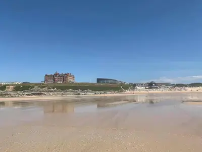 a view of a beach with a building in the background at Ocean Gate in Newquay