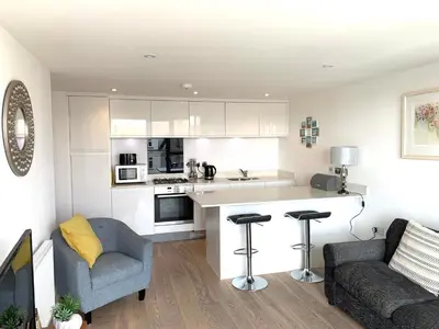 a kitchen and living room with a counter and chairs at Ocean Gate in Newquay