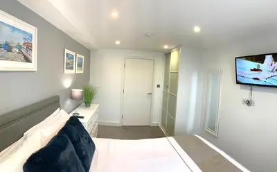 a bedroom with a bed and a flat screen tv at Ocean Gate in Newquay