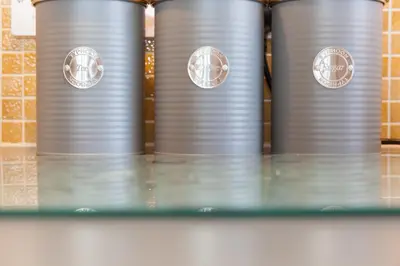 a row of silver tin cans on a shelf at Ocean Gem in Carbis Bay