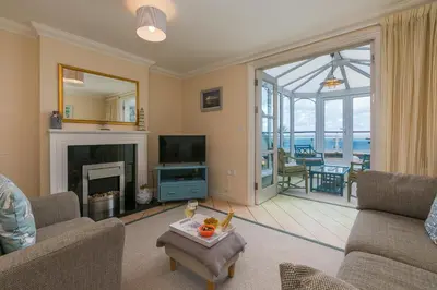 a living room with a fireplace and a television at Ocean Gem in Carbis Bay