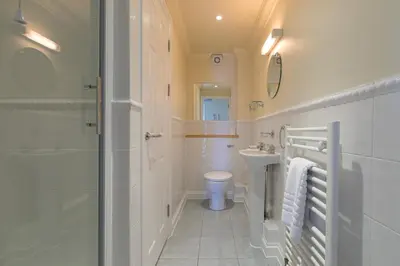 a bathroom with a shower and a toilet and a sink at Ocean Gem in Carbis Bay