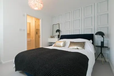 a white bedroom with a large bed with two pillows at Golden Heights in Carbis Bay