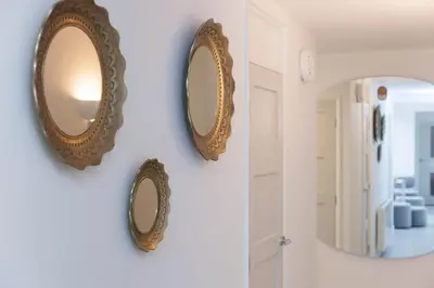 two mirrors hanging on a wall in a room at Golden Heights in Carbis Bay