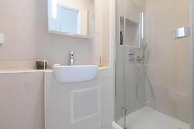 a white bathroom with a sink and a shower at Golden Heights in Carbis Bay