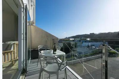 a balcony with a table and chairs on a balcony at Ithaca in St Ives