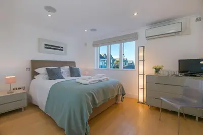 a bedroom with a bed and a television in it at Ithaca in St Ives
