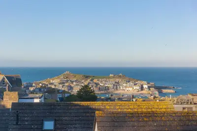 a view of a town with the ocean in the background at Ithaca in St Ives
