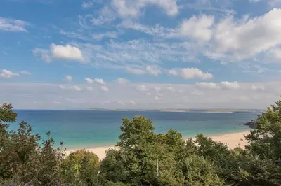 a view of a beach with trees and the ocean at Coast in St Ives