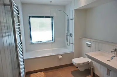 a bathroom with a shower and a toilet and a sink at Coast in St Ives