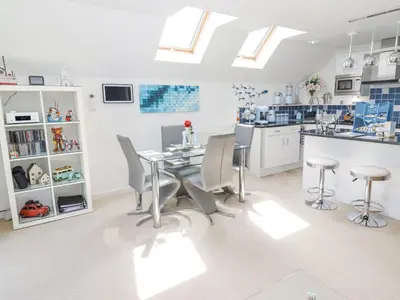 a kitchen with a table and chairs and skylights at Ocean Blue in Carbis Bay