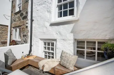 a balcony with a bench and a building at Mariners Cottage, St Ives in St Ives