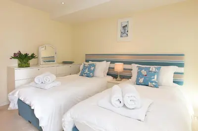 two beds with towels on them in a bedroom at Carbis Sands in Carbis Bay
