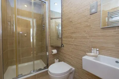 a bathroom with a toilet and a shower and a sink at Carbis Sands in Carbis Bay