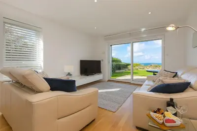 a living room with two couches and a tv at Carbis Sands in Carbis Bay