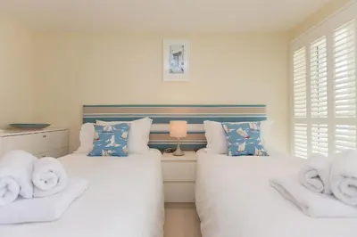 a bedroom with two beds with towels on them at Carbis Sands in Carbis Bay