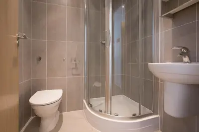 a bathroom with a shower and a toilet and a sink at Serendipity in St Ives