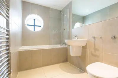 a bathroom with a sink and a toilet and a window at Serendipity in St Ives