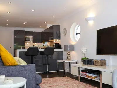 a living room with a couch and a kitchen at Serendipity in St Ives