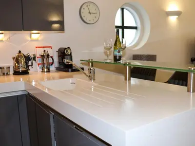 a kitchen with a sink and a clock on the wall at Serendipity in St Ives