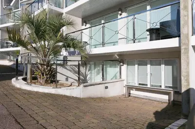 a building with a palm tree in front of it at Tides in St Ives