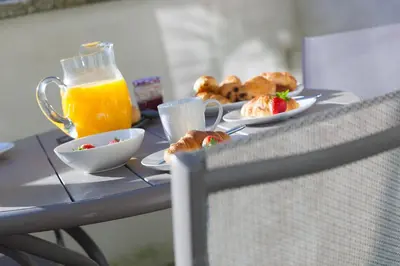 a table with plates of food and a pitcher of orange juice at Tides in St Ives