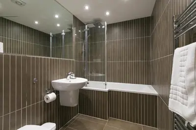 a bathroom with a sink and a toilet and a shower at Tides in St Ives