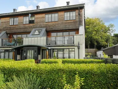 a large brick house with windows and a balcony at Bluebell Retreat in Lostwithiel