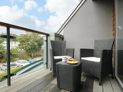a patio with chairs and a table on a balcony at Bluebell Retreat in Lostwithiel