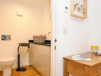 a bathroom with a toilet and a wooden table at Bluebell Retreat in Lostwithiel