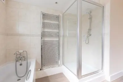 a bathroom with a shower and a bath tub with a shower at Sowena in Carbis Bay