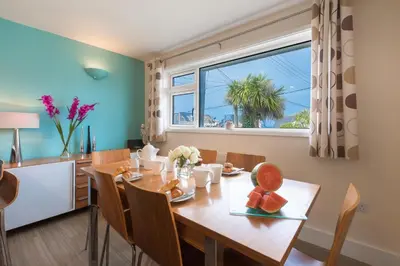 a dining room with a table and a window at Sowena in Carbis Bay