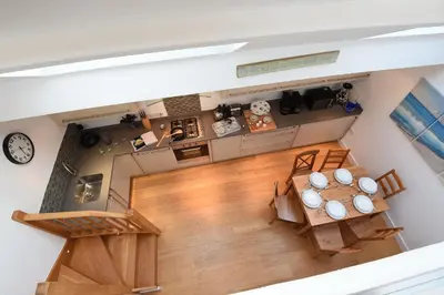 an overhead view of a kitchen and dining room with a table at The Sail Loft in St Ives