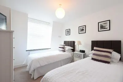 a bedroom with two beds and a window at The Sail Loft in St Ives