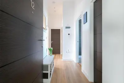 a hallway with white walls and wood floors at Sea Vista in Carbis Bay